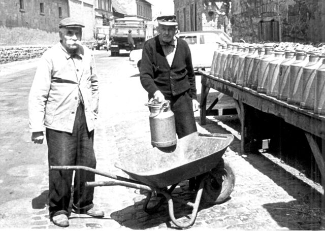 Karl Correll (li) und Johann Janson (re) beim Abholen der leeren Milchkannen an der Bechenheimer Straße